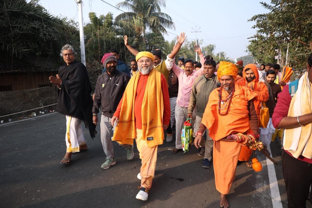 Swami Debananda Maharaj walking along a road at the head of a procession of monks and devotees