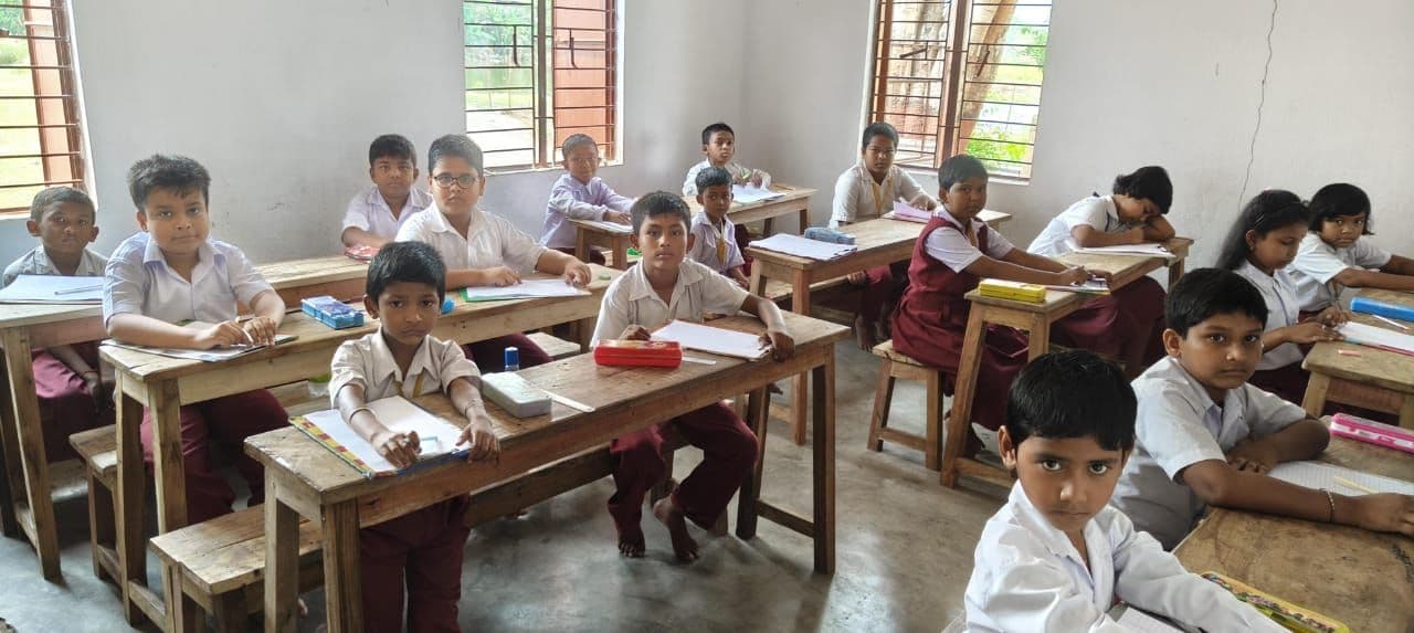 Students seated at wooden desks in a classroom